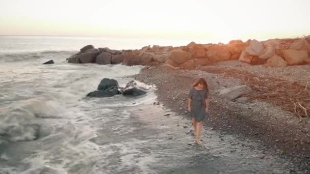 Kvinna promenad på stranden vid solnedgången — Stockvideo