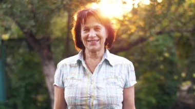 Gün batımında gülümseyen orta yaşlı kadın portresi