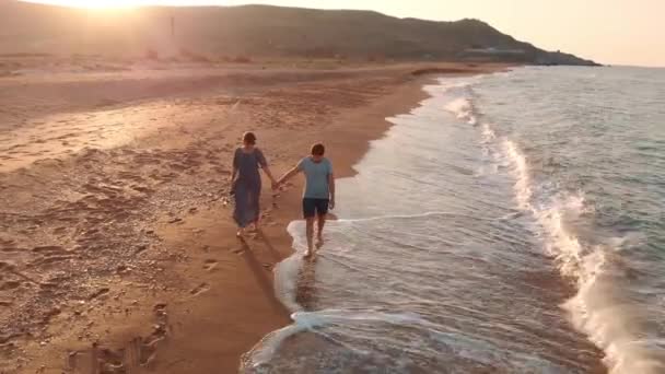 Pareja joven caminando en la playa — Vídeo de stock