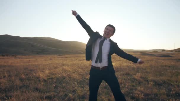 Homme d'affaires se réjouit et saute sur la nature — Video