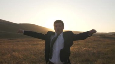 İşadamı sevinir ve doğa üzerinde dans ediyor