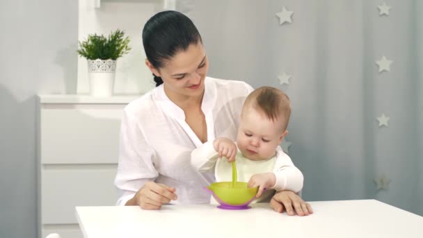 Mãe ajudando bebê com comer por si mesma — Vídeo de Stock