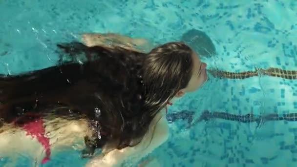 Vrouw in bikini zwemmen in het zwembad — Stockvideo