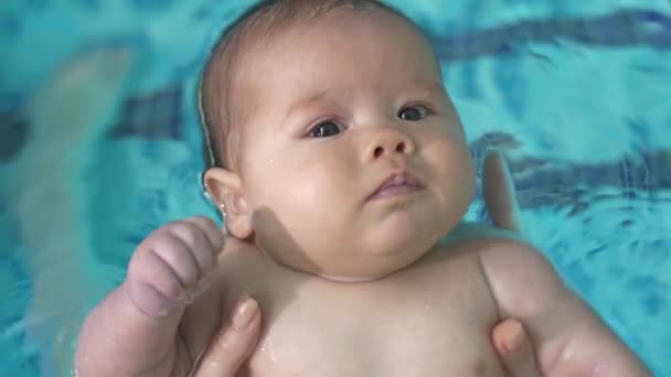 Schattige baby in het zwembad — Stockvideo