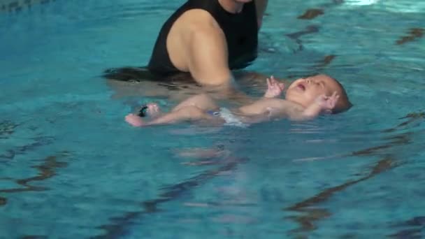 Тренер учит ребенка плавать — стоковое видео