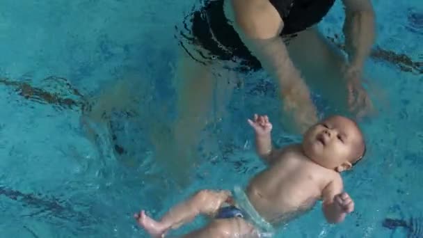 Тренер учит ребенка плавать — стоковое видео