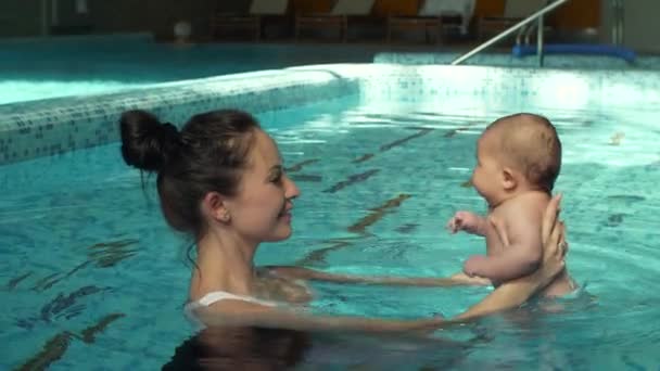 Mãe segura bebê na piscina — Vídeo de Stock