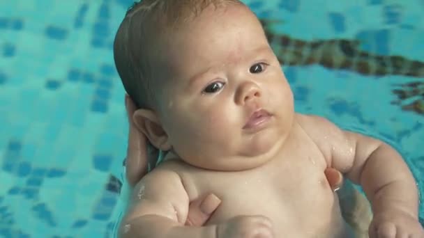 Bebê em uma mãe mãos na piscina — Vídeo de Stock