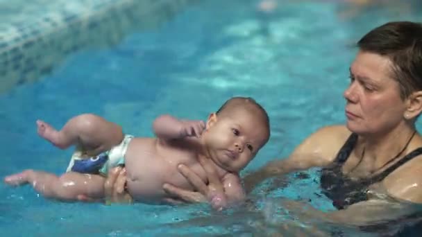 Baby doing exercises in the pool — Stock Video