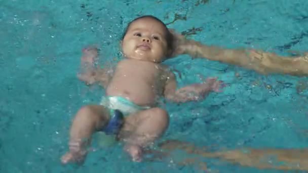 Bebé en una mano nadando en la piscina — Vídeo de stock