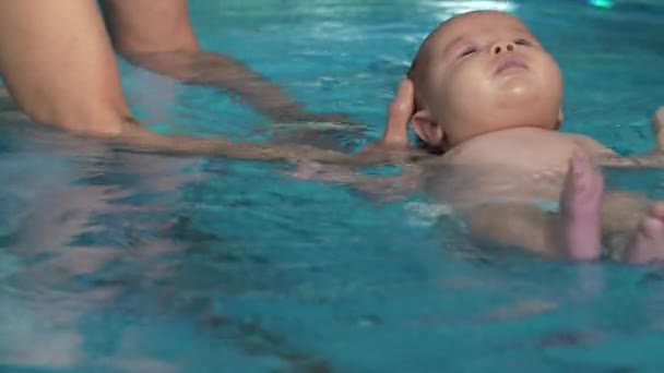 Мама помогает ребенку плавать — стоковое видео
