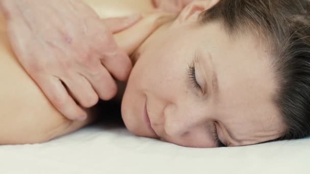 Женщина с закрытыми глазами получает массаж — стоковое видео