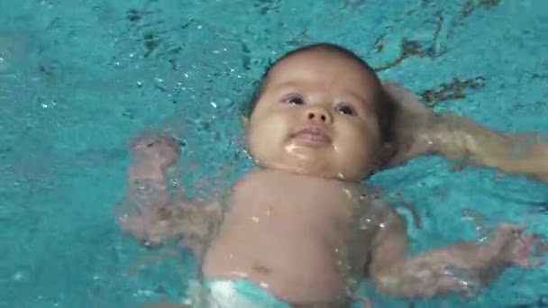 Bebé en una mano nadando en la piscina — Vídeo de stock