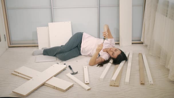 Жінка лежить на частинах меблів — стокове відео