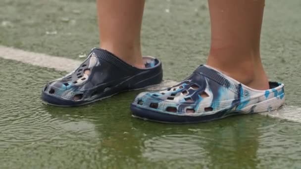 Hombre en zapatillas de goma bajo la lluvia — Vídeo de stock