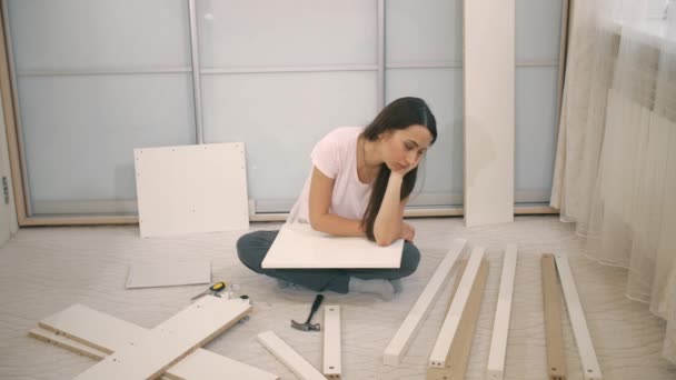 Traurige Frau kippt Möbel zu montieren — Stockvideo