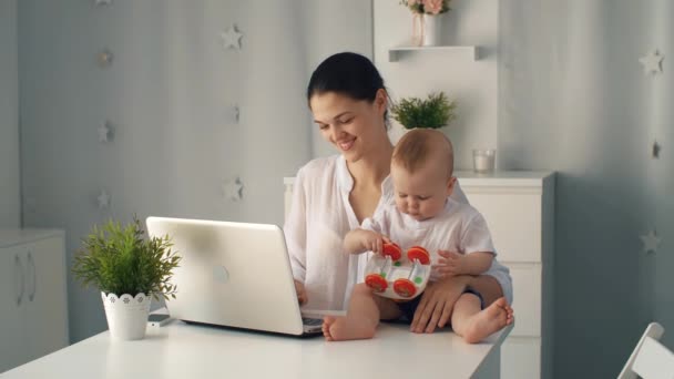 Vrouw met baby en laptop — Stockvideo