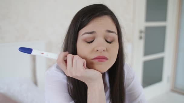 Depressieve vrouw met zwangerschapstest op de kamer — Stockvideo