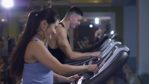 Hombre y mujer en una cinta de correr — Vídeo de stock