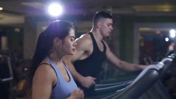 Hombre y mujer corriendo en una cinta de correr — Vídeos de Stock
