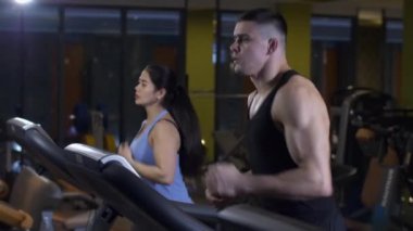 Spor salonunda koşan erkek ve kadın