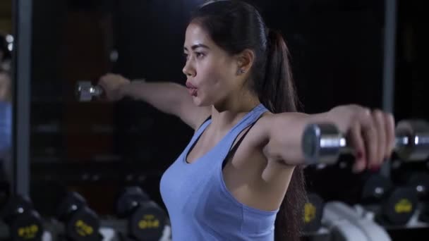 Женщина делает упражнения с гантелями — стоковое видео