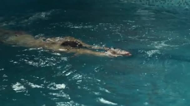 Человек в бассейне ползает в стиле плавания — стоковое видео