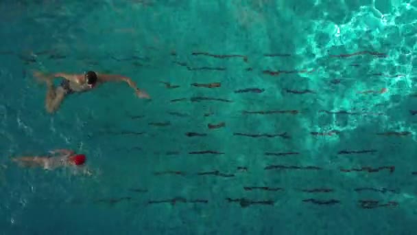 Instrutor ensinando uma menina nadando em uma piscina — Vídeo de Stock