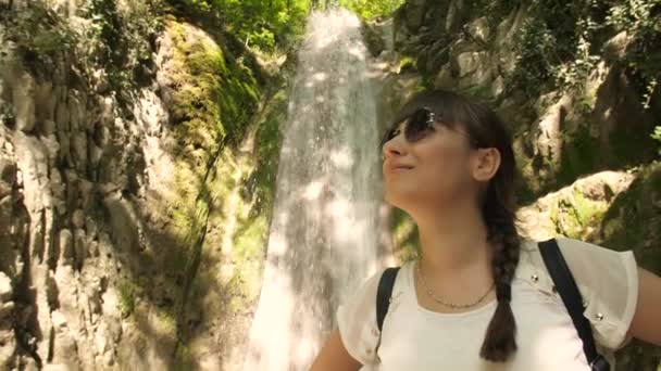 Mujer cerca de cascada disfrutando de la naturaleza — Vídeos de Stock