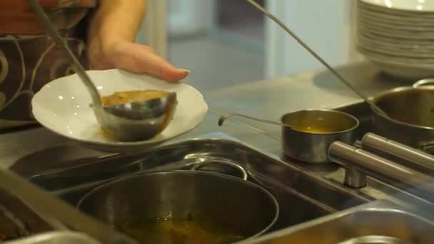Köchin in Kantine gießt Suppe ein — Stockvideo