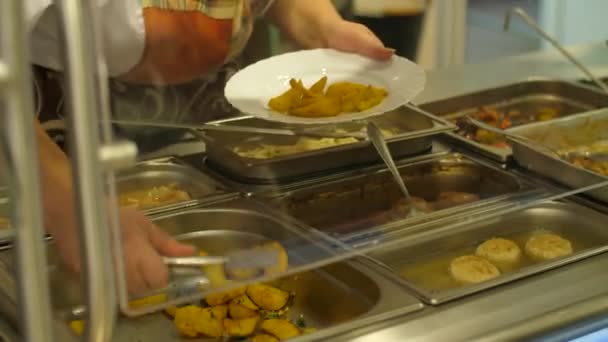 Cozinhe em uma cantina põe batatas — Vídeo de Stock