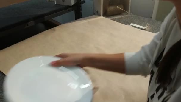 Жінка обгортає нові тарілки після покупок — стокове відео