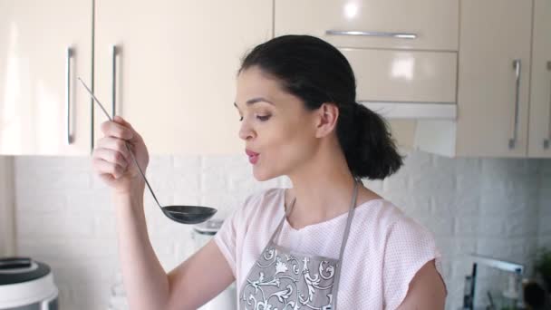 Жінка смакує суп перед подачею — стокове відео