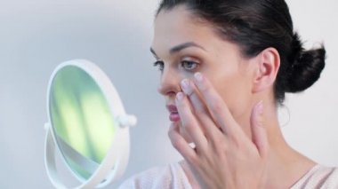 kadının yüzündeki kozmetik krem tedavisi uygulamak