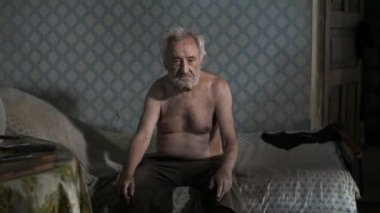 Yatakta oturan dilenci adam