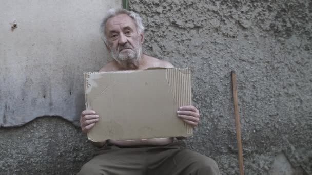 Homem sem-teto com um sinal pedindo ajuda — Vídeo de Stock