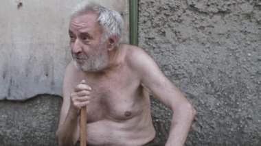 Sokakta oturan bastonlu yaşlı adam