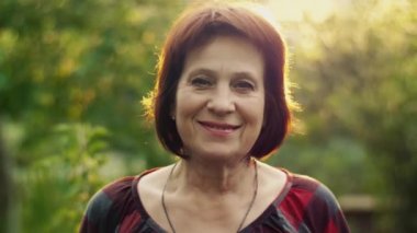 Günbatımı üzerinde yaşlı gülümseyen kadın