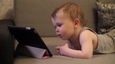 Biraz ciddi ve yalnız çocuk Kız oturan ve tablet dizüstü bilgisayararanıyor