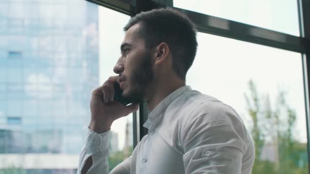 Молодий бізнесмен розмовляє по телефону — стокове відео