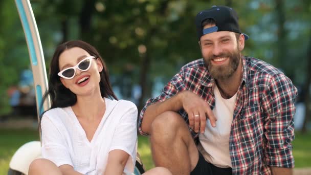 Uomo e donna sorridenti seduti sull'erba — Video Stock