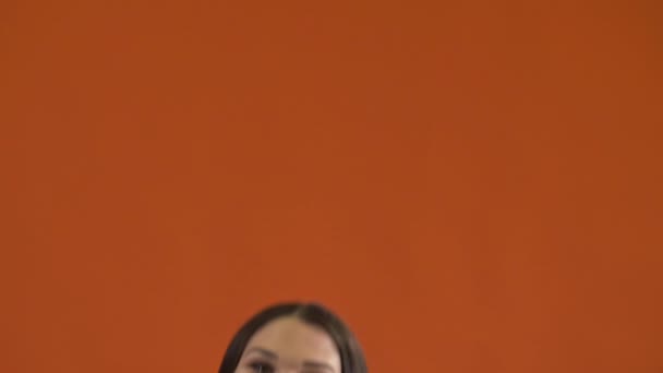 Mulher pulando no fundo laranja — Vídeo de Stock