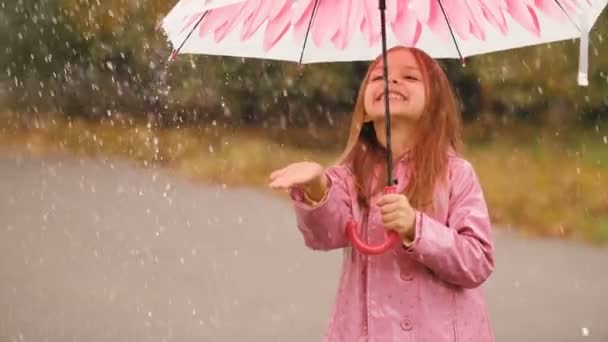 Klein meisje onder paraplu bij regen — Stockvideo