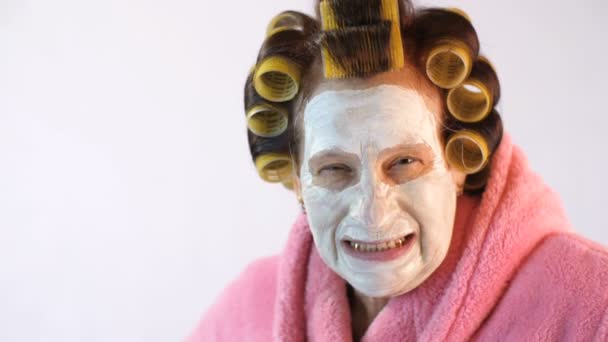 Angry wife with a cosmetic mask and curlers — Stock Video