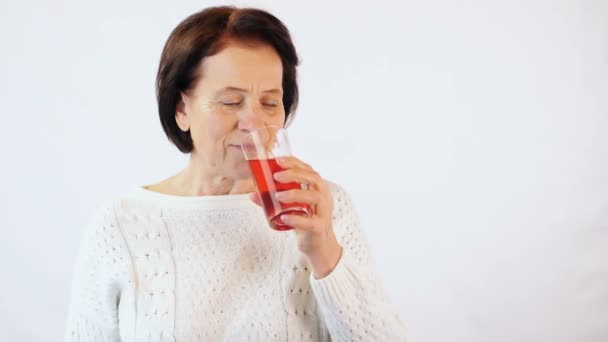 Ηλικιωμένη γυναίκα που πίνει κόκκινο χυμό — Αρχείο Βίντεο