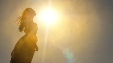 Bir kadının silueti güneşe karşı