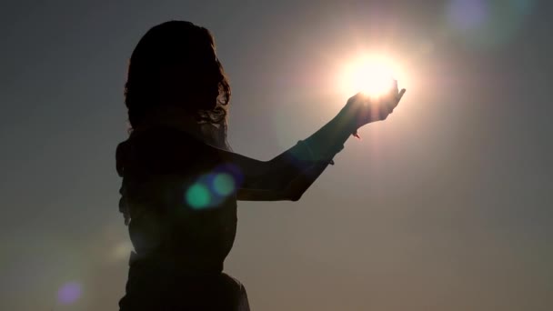 Mulher segura o sol em suas mãos — Vídeo de Stock