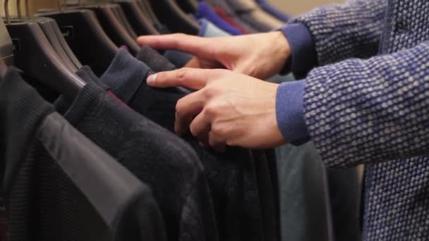 De man die kleding kiest in de winkel — Stockvideo