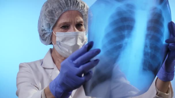 O médico olha para a radiografia dos pulmões. Conceito de coronavírus . — Vídeo de Stock