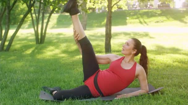 Gravid kvinna gör övningar på naturen — Stockvideo